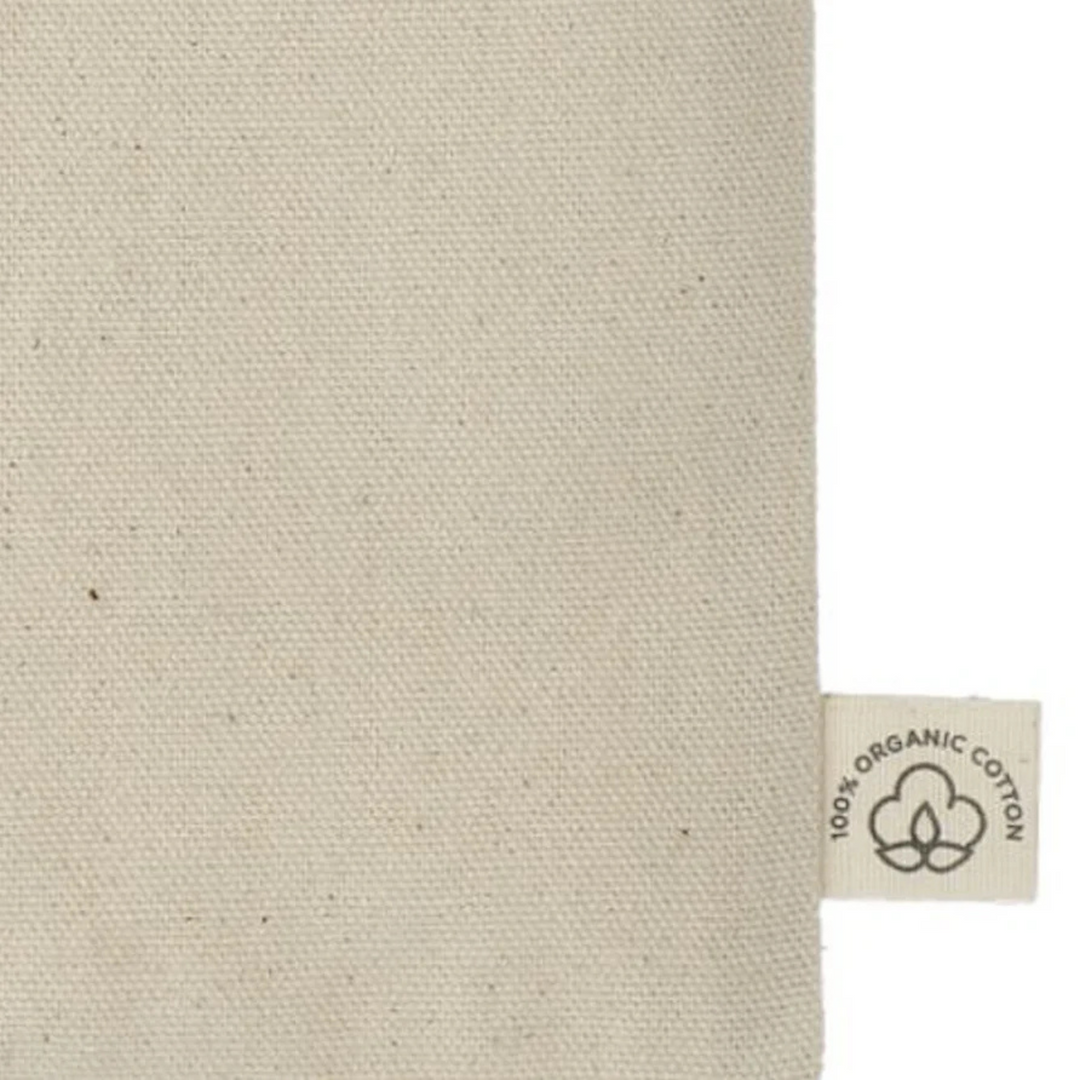 Close-up of fabric tag on 'One More Chapter' Organic Cotton Tote Bag indicating 100% organic cotton material.