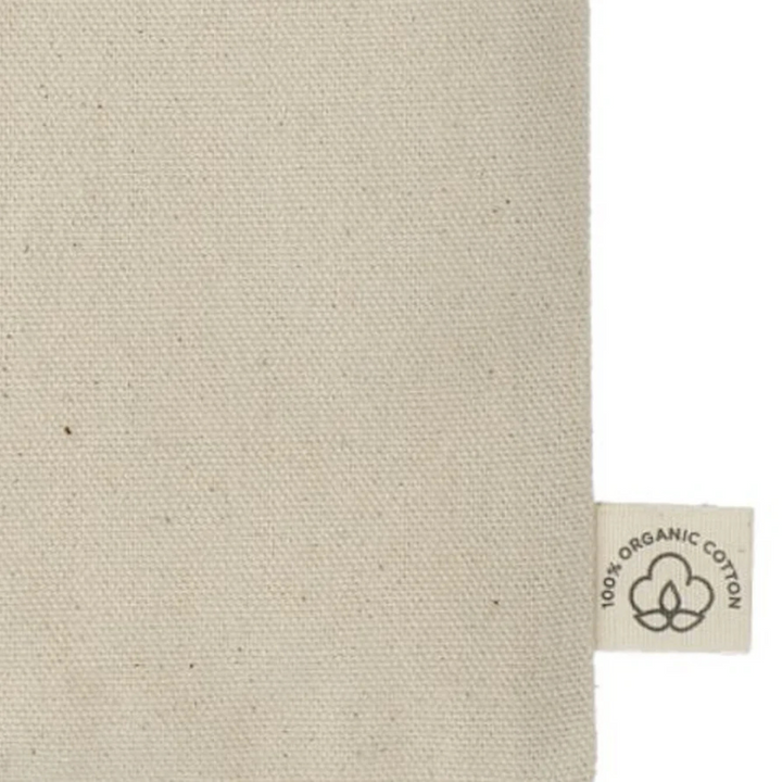 Close-up of fabric tag on 'One More Chapter' Organic Cotton Tote Bag indicating 100% organic cotton material.