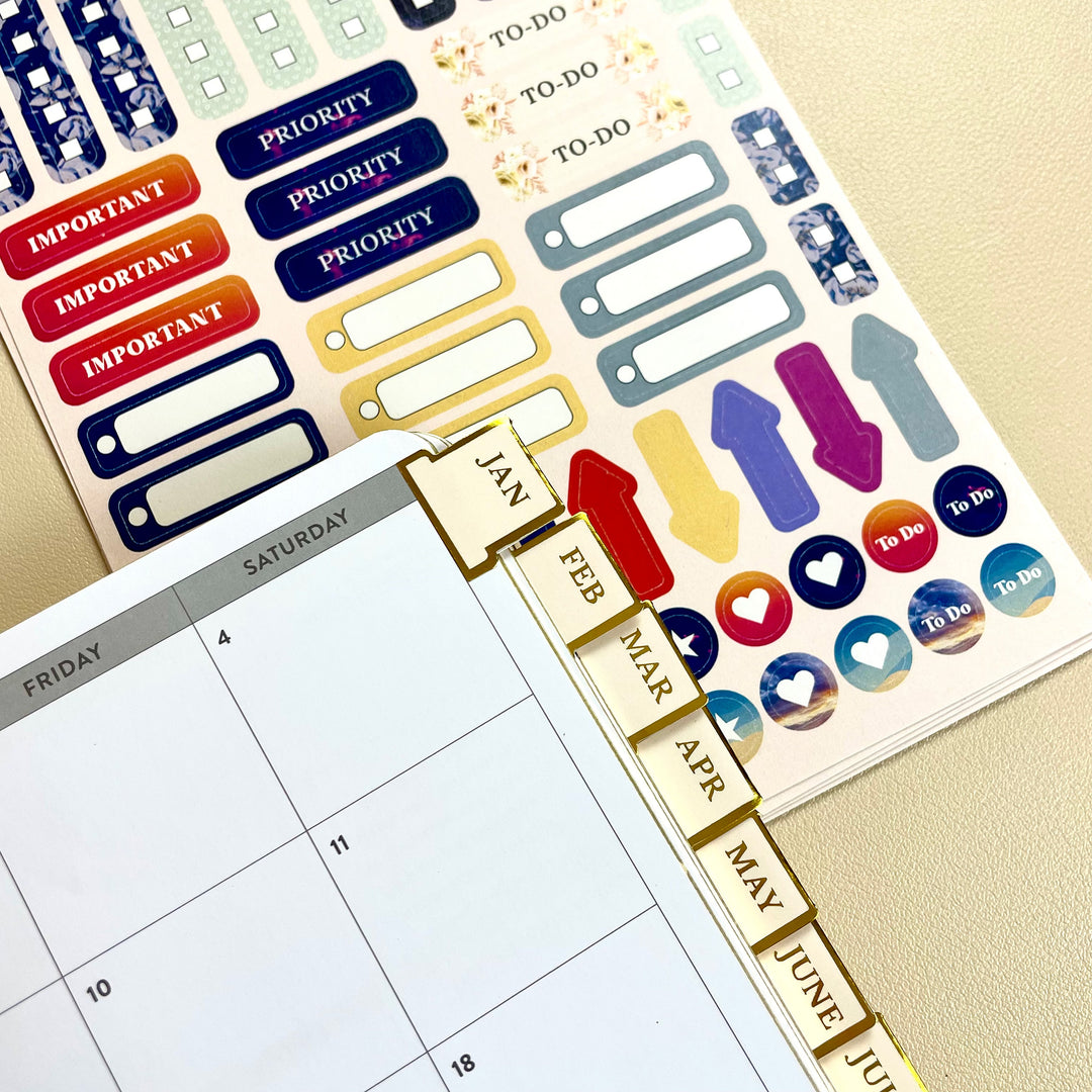 Close-up of monthly tab stickers from Purposeful Planning Stickers for Journals & Planners applied to a calendar for streamlined monthly planning.