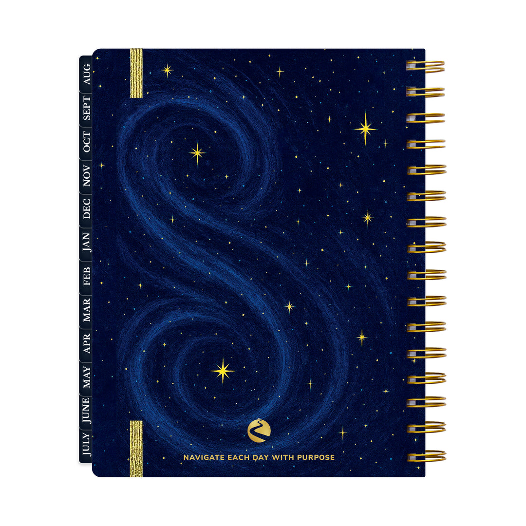 Back of 12-month planner with starry night design and gold spiral binding on a white background 