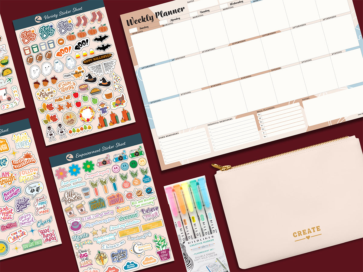 Picture Links to Define's Planner Accessories. This picture includes: Empowerment Sticker Sheets, Weekly Desk Planner, Zebra Mildliners Markes, and the Planny Pouch.