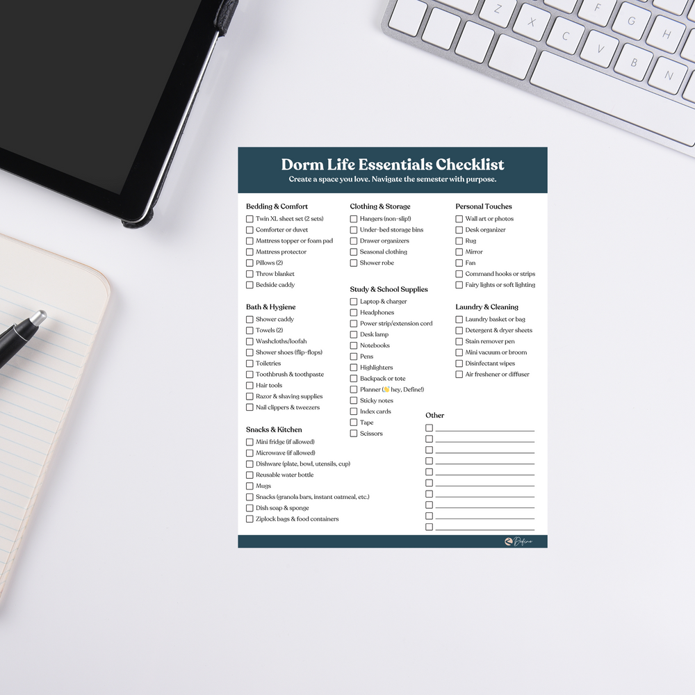 Dorm Life Essentials Checklist notepad on white desk with keyboard, tablet, and pen. Ideal for students organizing school supplies and dorm needs.
