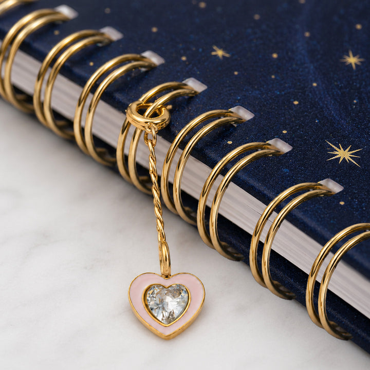 Heart charm clipped onto the spiral of a starry planner 