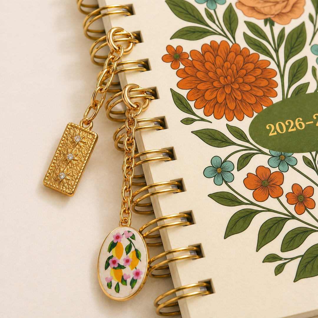Gold tile charm and lemon floral charm connected to planner spiral 
