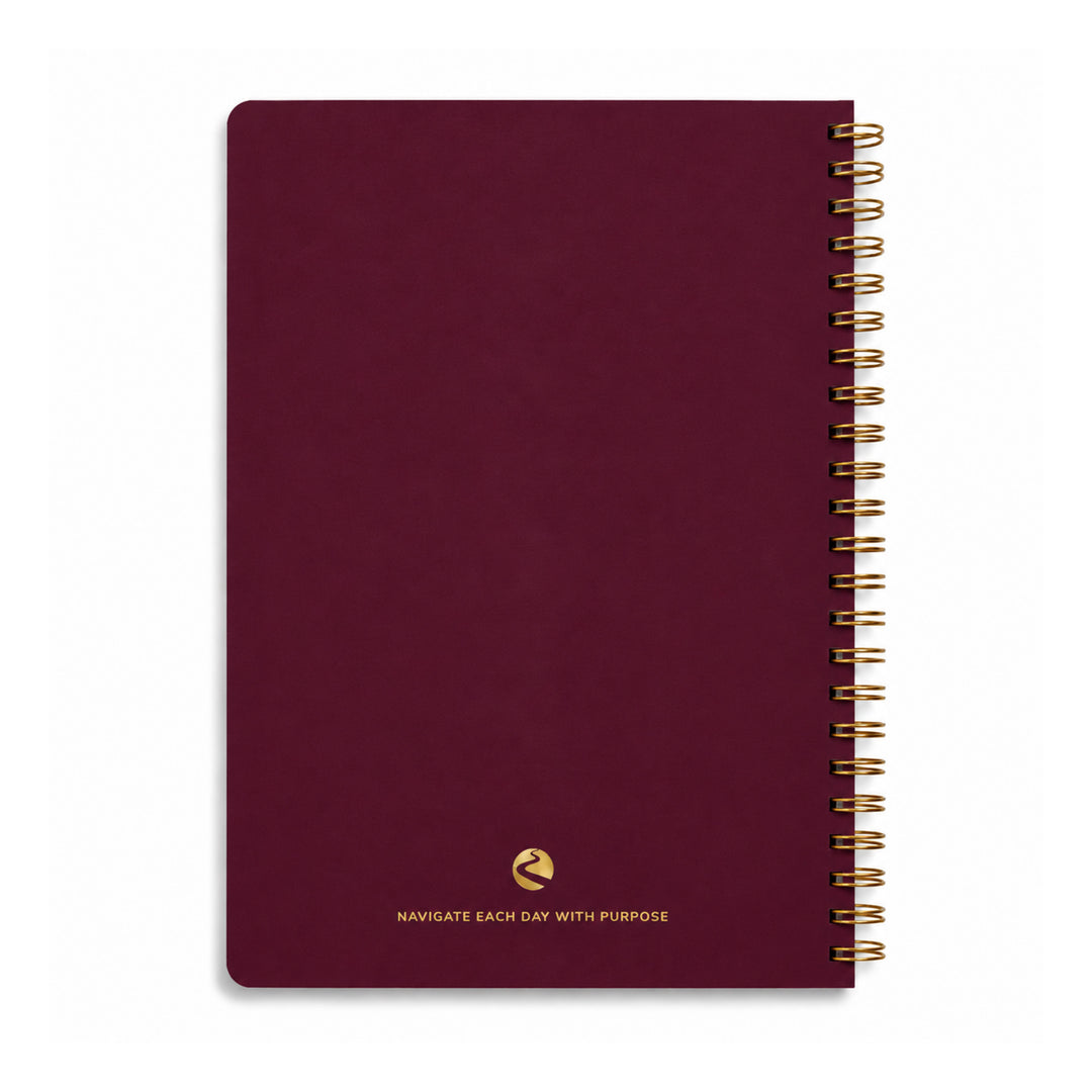 Maroon notebook with gold spiral binding on a white background 