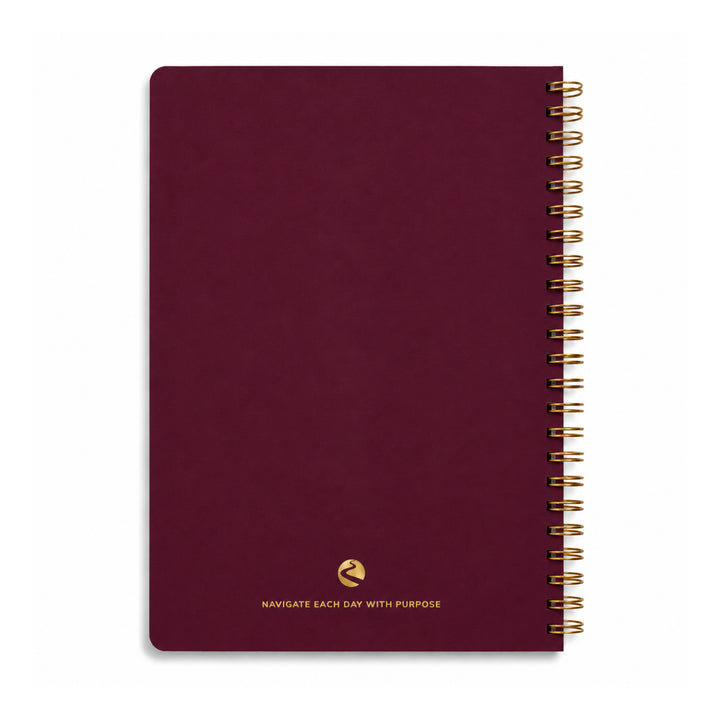 Maroon notebook with gold spiral binding on a white background 