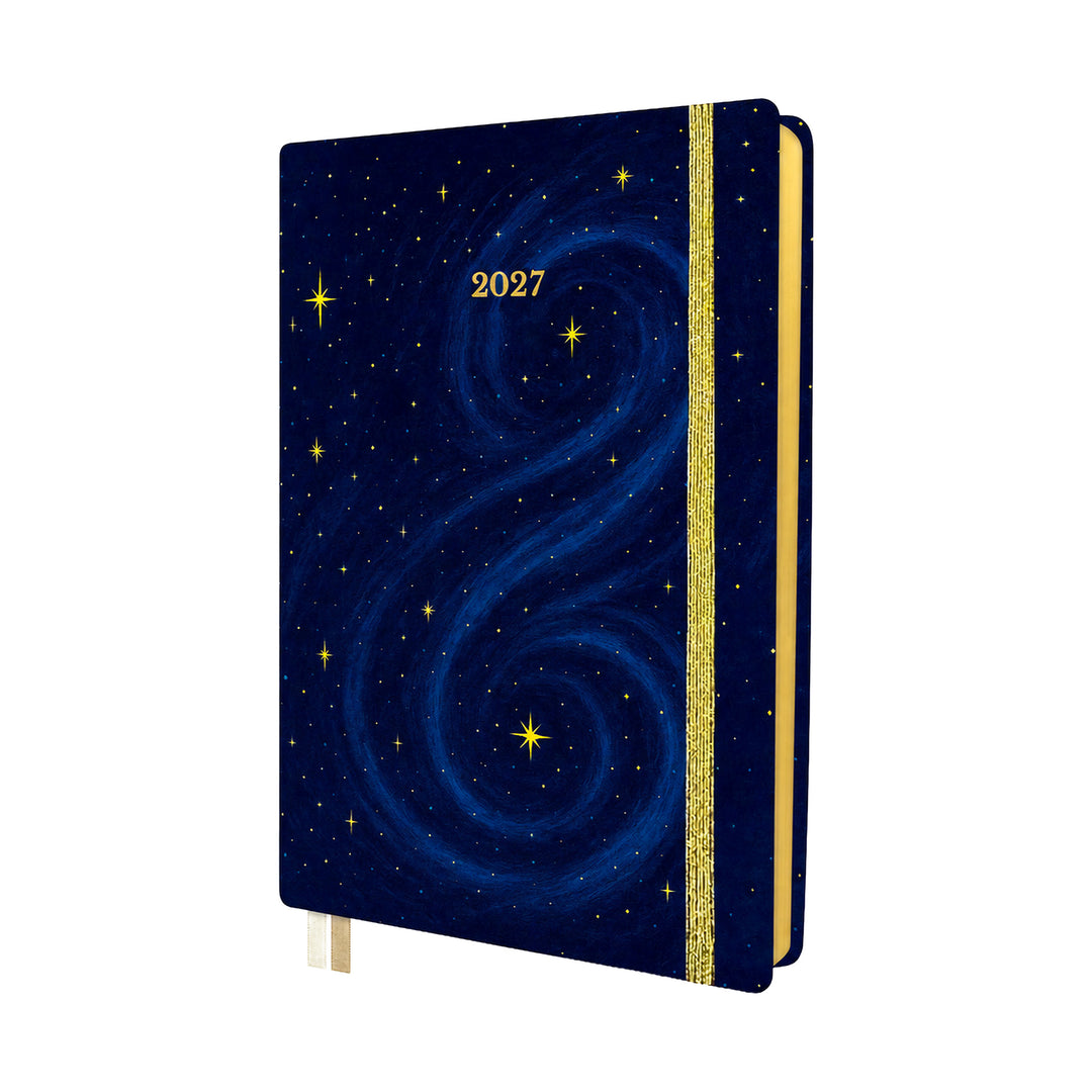 A 2027 hardcover planner or journal with a deep navy blue cover decorated with a swirling galaxy pattern and small gold stars. It features a vertical gold glitter elastic closure band and a gold page edge, with a gold ribbon bookmark hanging from the bottom. #color_midnight-galaxy