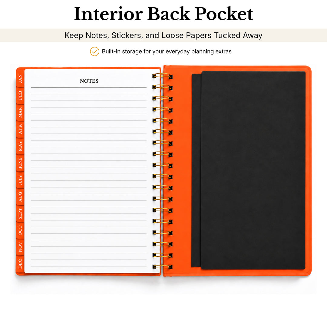 An open spiral-bound notebook with a bright orange cover, showing a lined notes page on the left and a black interior back pocket on the right. Text above reads &