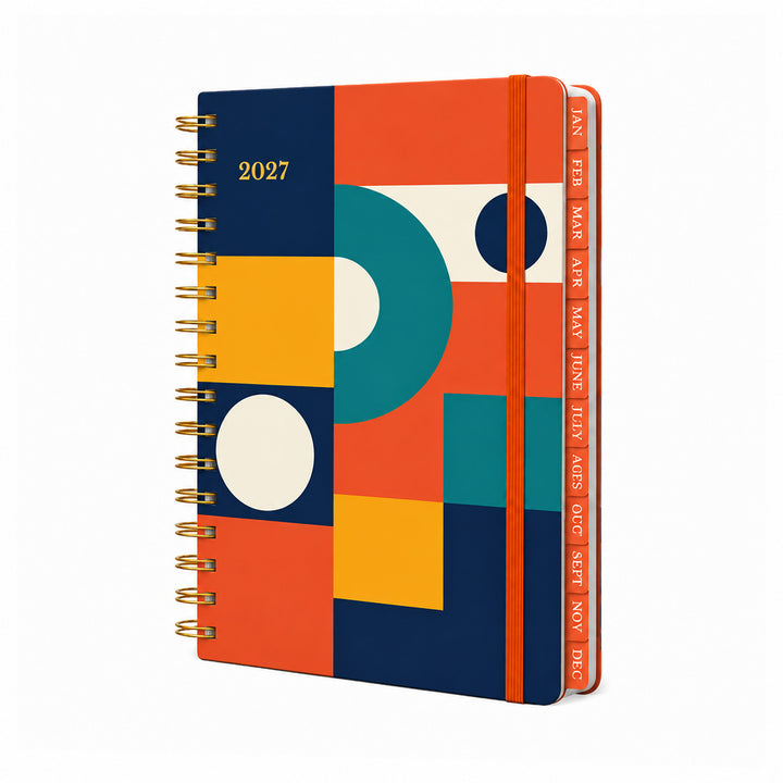 A 2027 spiral-bound planner with a colorful geometric cover design in navy, orange, teal, yellow, and white. The side tabs show the months from JAN to DEC in orange. 