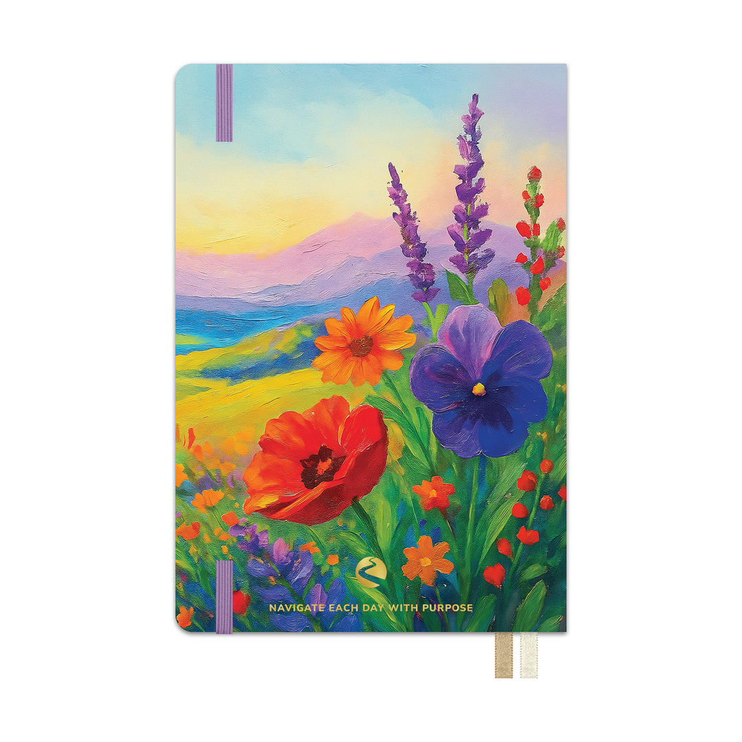 A hardcover journal featuring a colorful landscape painting of wildflowers, including a red poppy, blue pansy, and purple lavender, with the text &