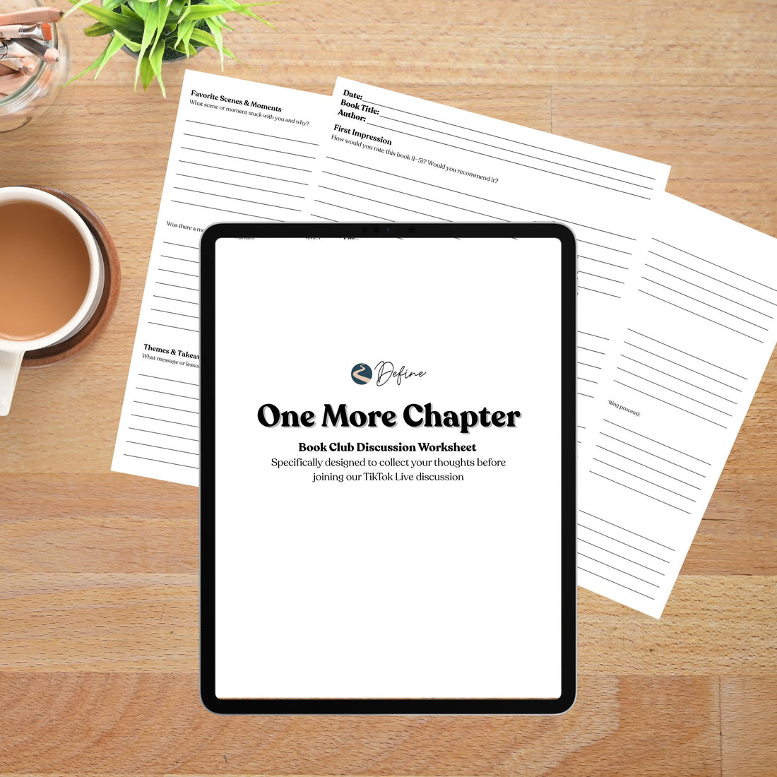 Tablet displaying 'One More Chapter' book club discussion worksheet on a wooden surface with a cup of tea and plant. Surrounded by printed out worksheets. 