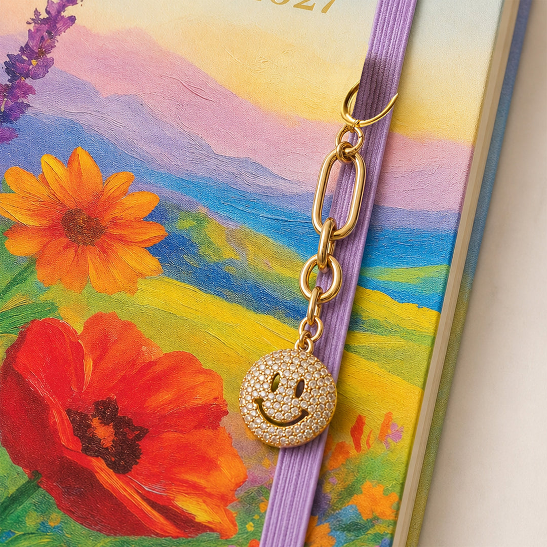 Smiley face gem stone chain attached to the elastic band of planner 