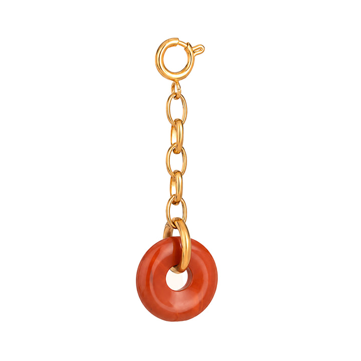 Gold chain with a red circular charm on a white background 