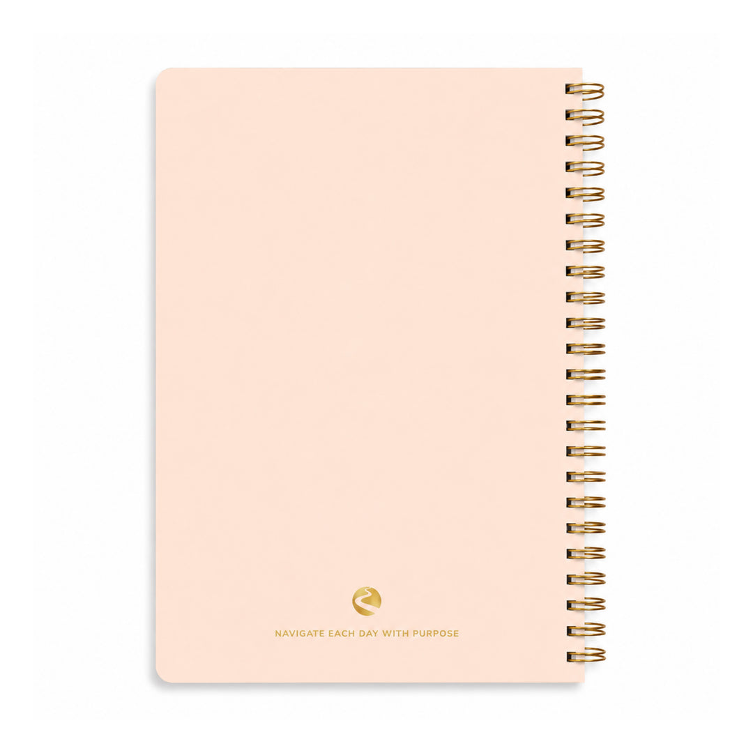 Pink notebook with gold spiral binding on a white background 