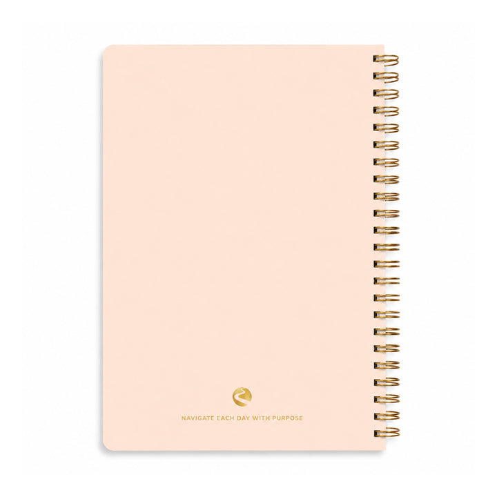 Pink notebook with gold spiral binding on a white background 