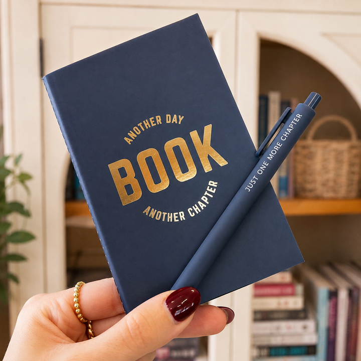 Person holding the book booklet and pen in front of a bookshelf 