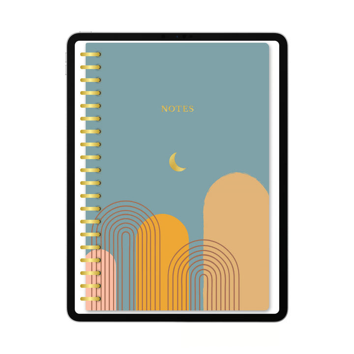 A spiral-bound notebook with a black frame and a muted blue cover featuring a yellow crescent moon, gold &