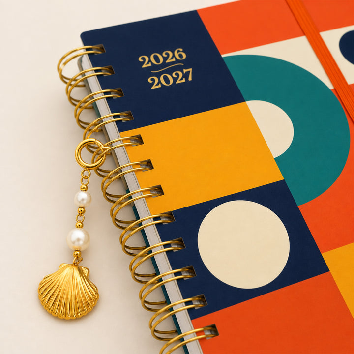 Colorful planner with geometric design and gold spiral binding on a beige background 